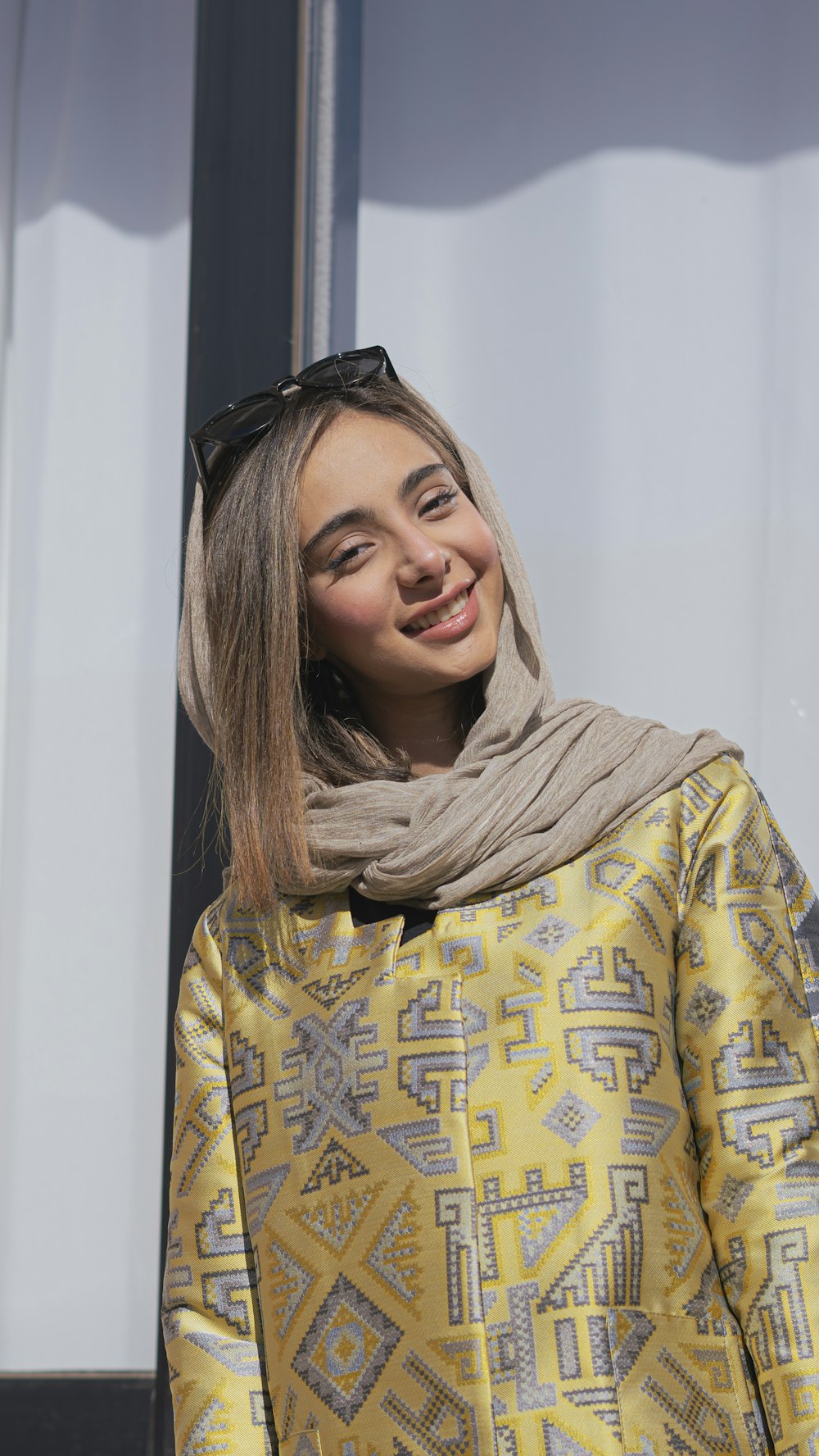 a woman wearing a yellow jacket and scarf