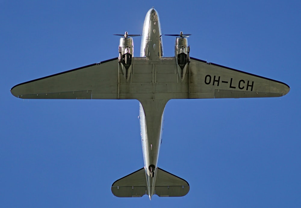 a plane flying in the air with a blue sky in the background