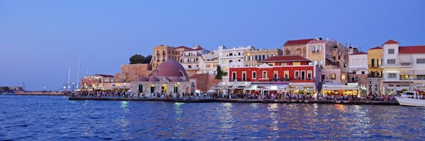 A harbor filled with lots of boats next to tall buildings — Crete, Greece