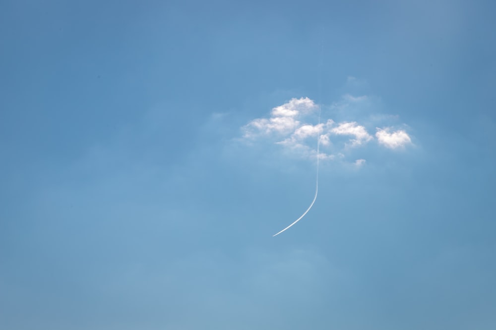 a plane flying in the sky with a contrail in the sky