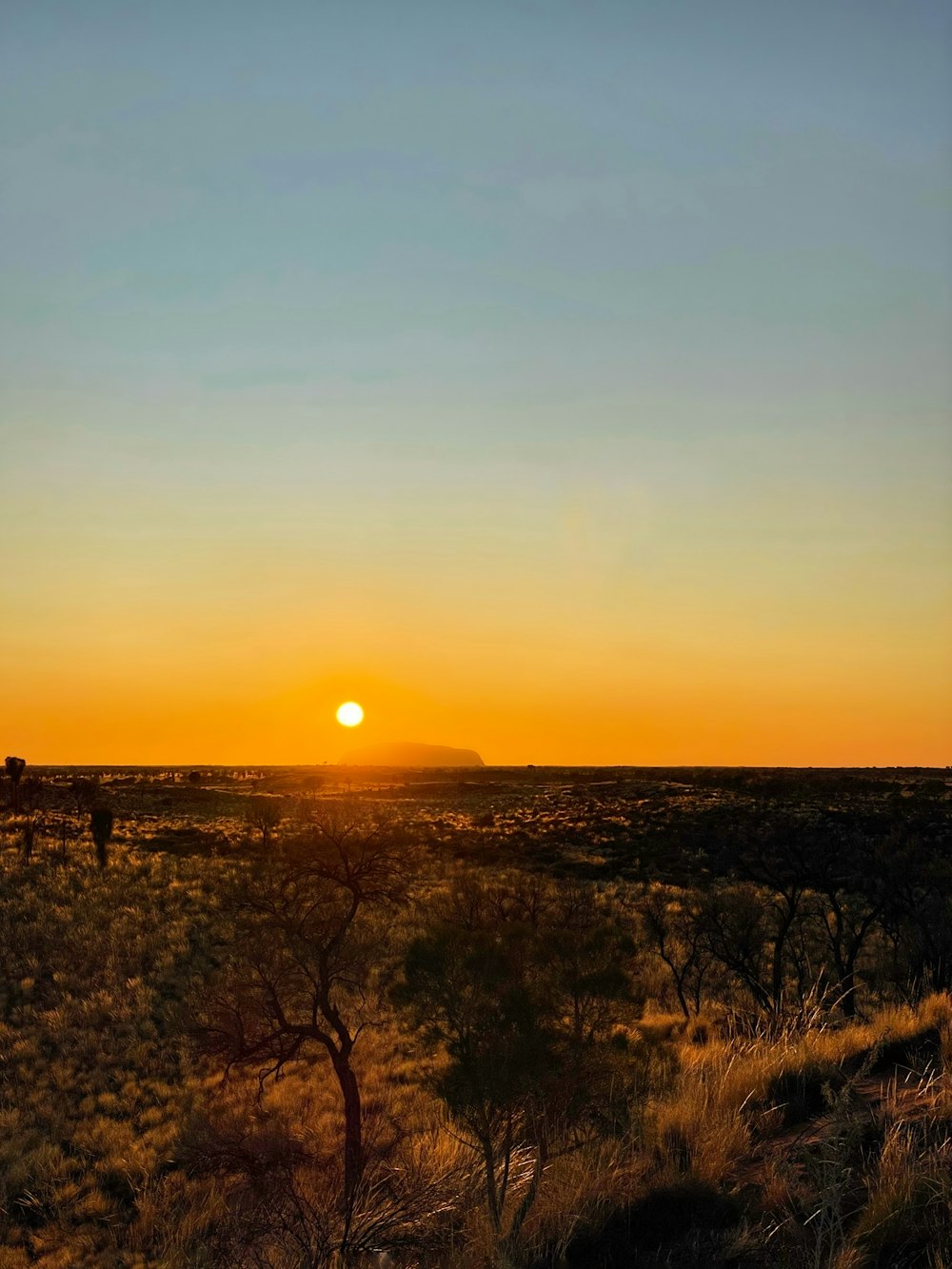 the sun is setting over a desert plain