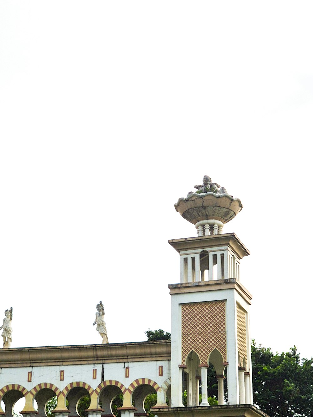 a clock tower with statues on top of it