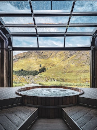 a hot tub in a room with a view of mountains