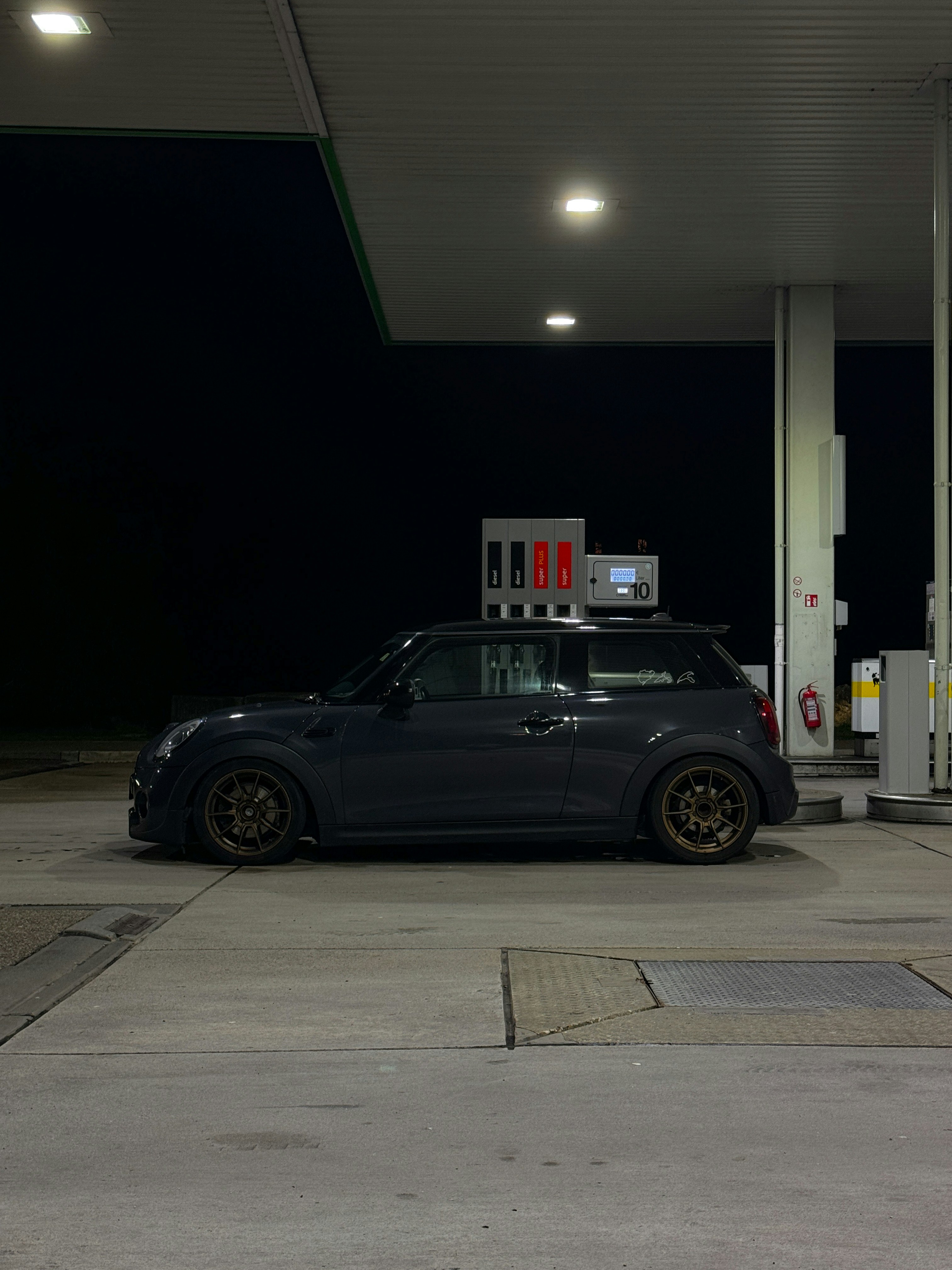 a car parked at a gas station at night