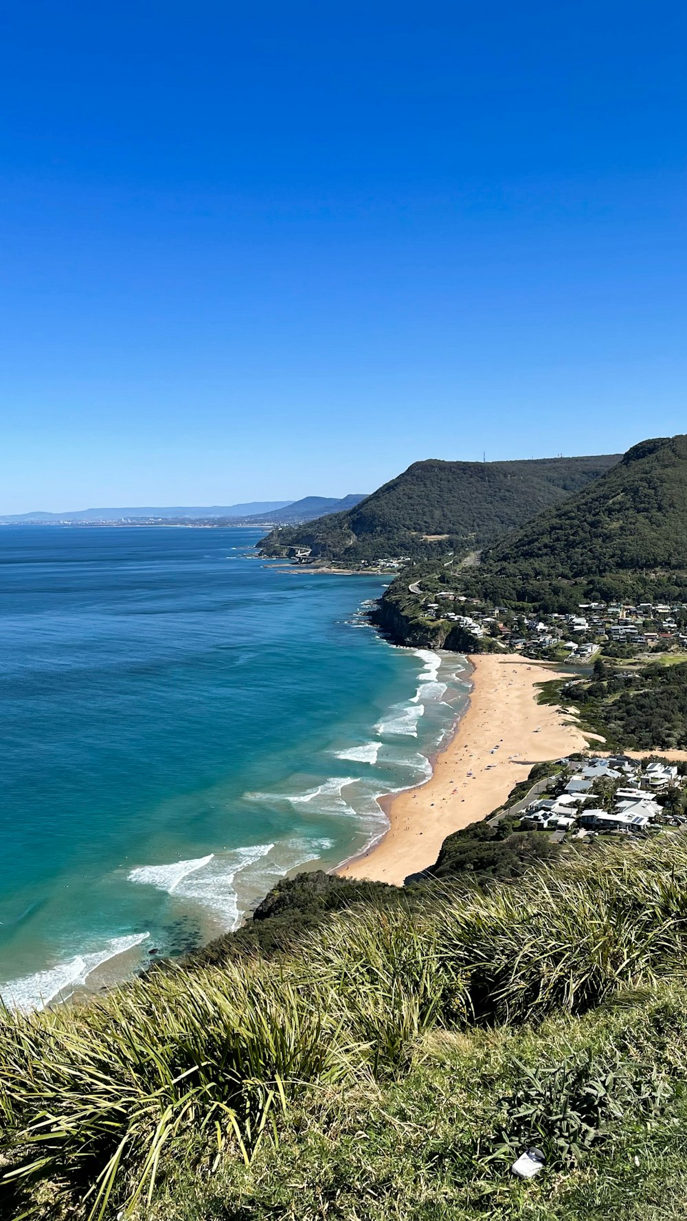 a view of a beach and the ocean from a hill