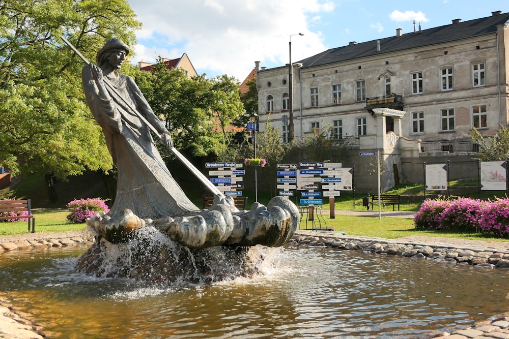 una fuente con una estatua de un hombre sosteniendo un bastón