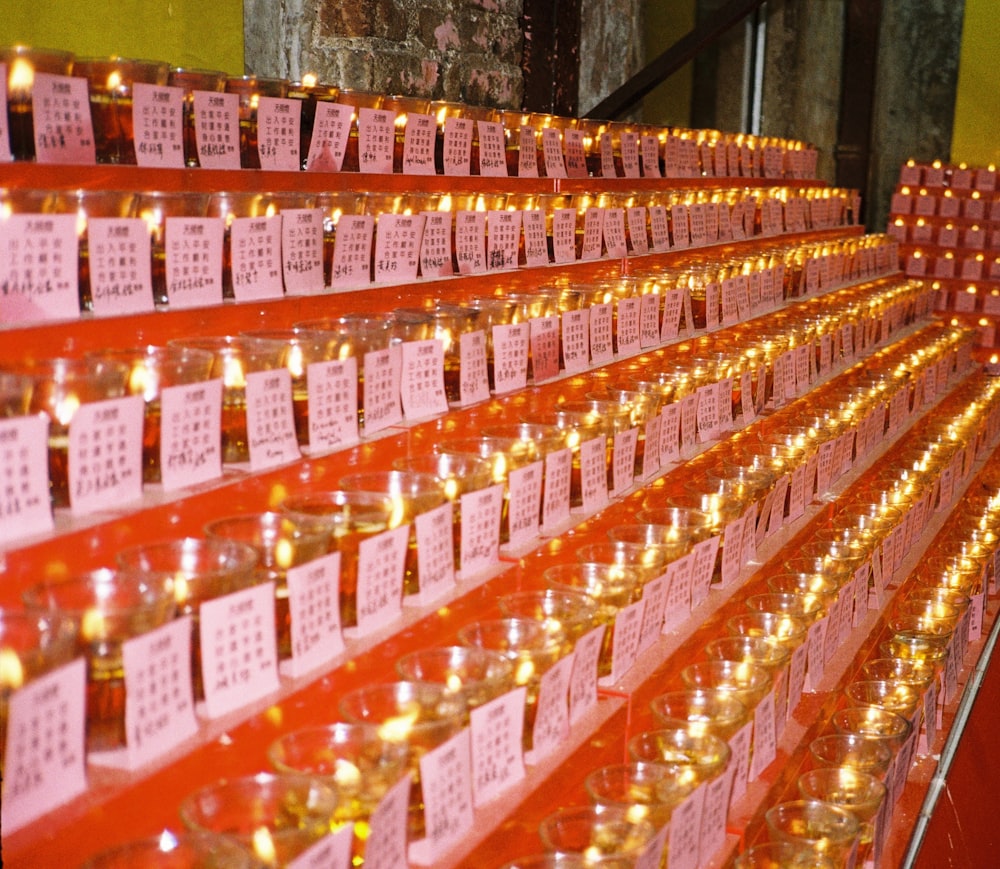 rows of candles are lined up against a wall