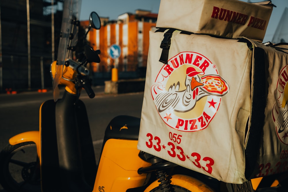 a yellow scooter with a bag on the back of it