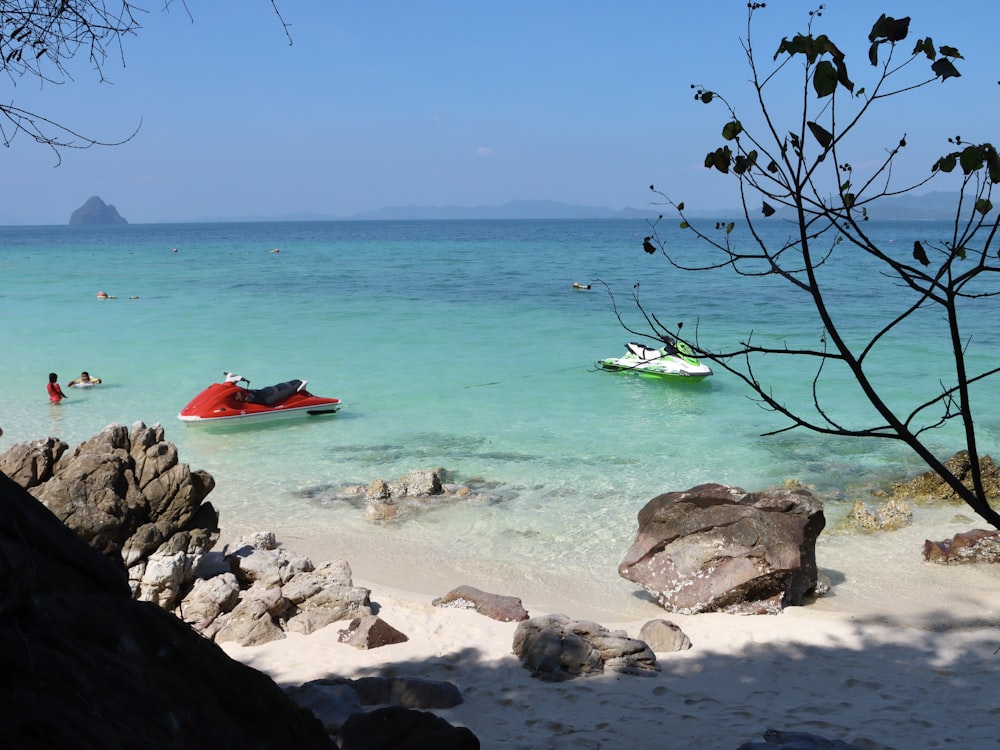 a beach with a boat and people in the water