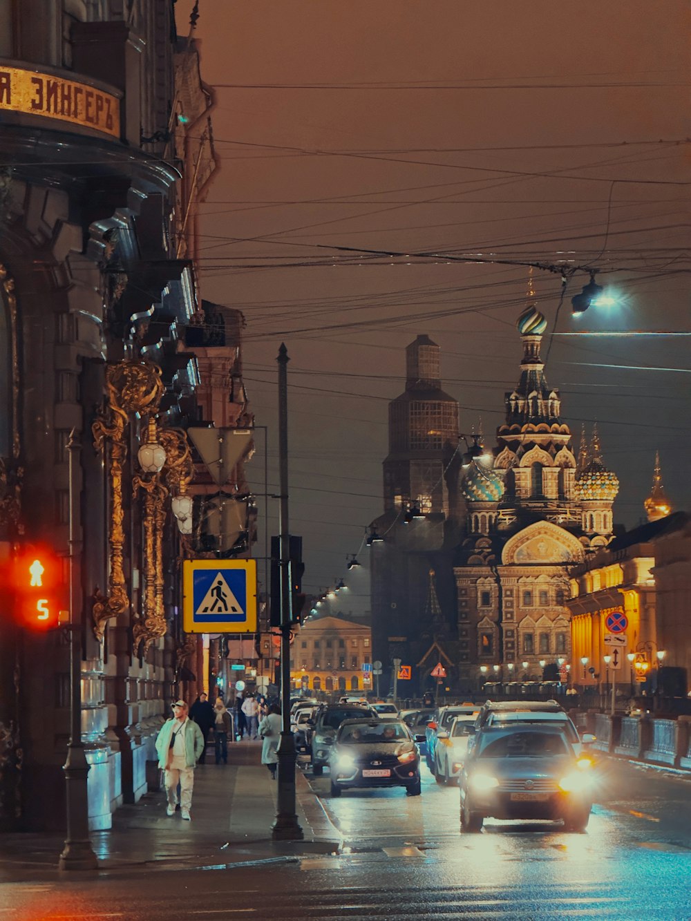 a city street at night with cars and people