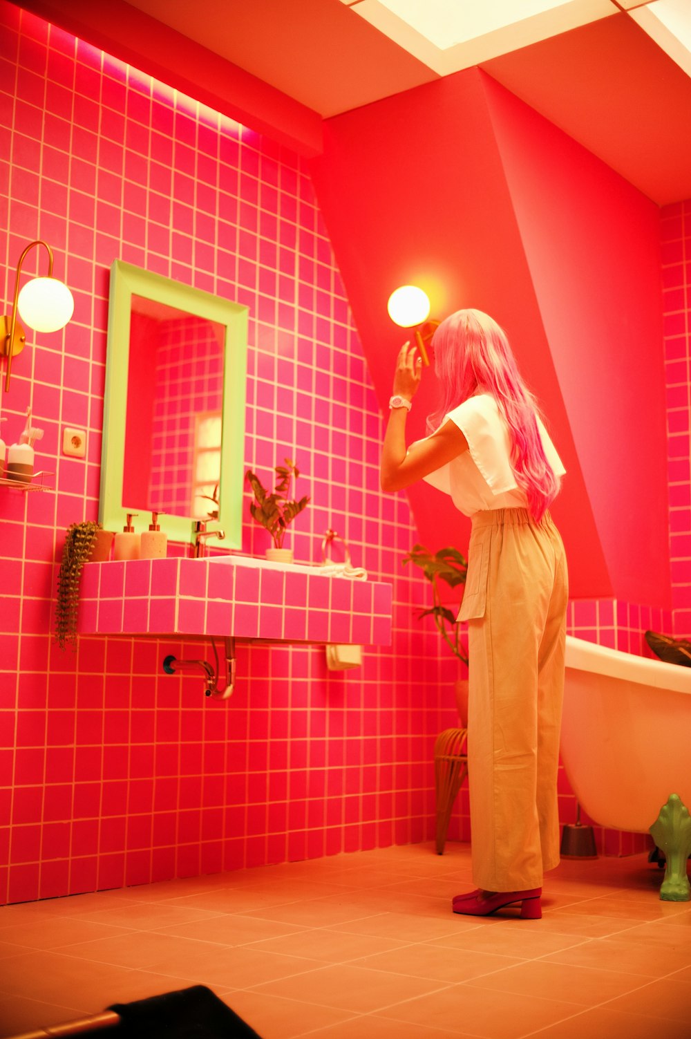 a woman with pink hair standing in a bathroom