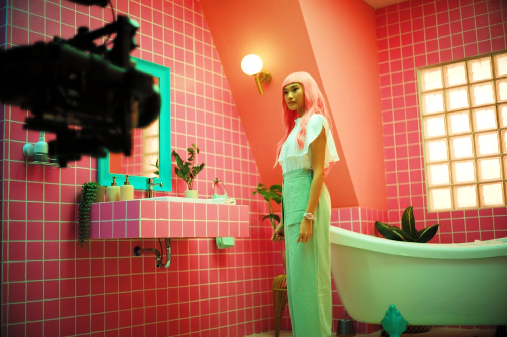 a woman standing in a bathroom next to a tub