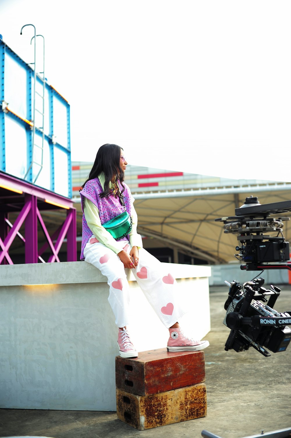 a woman sitting on top of a piece of luggage