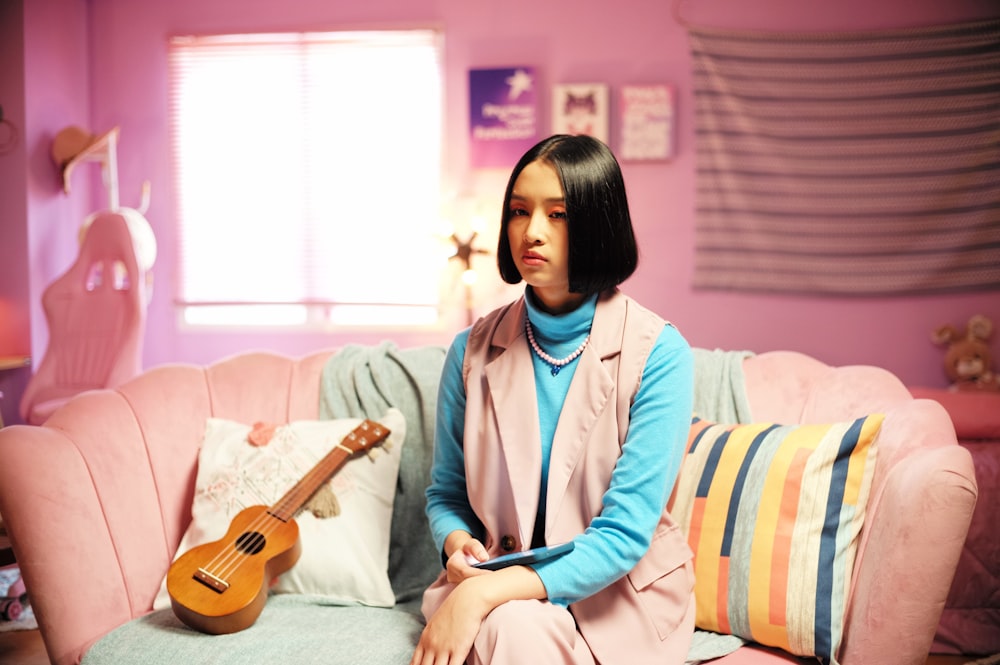 a woman sitting on a couch with a guitar