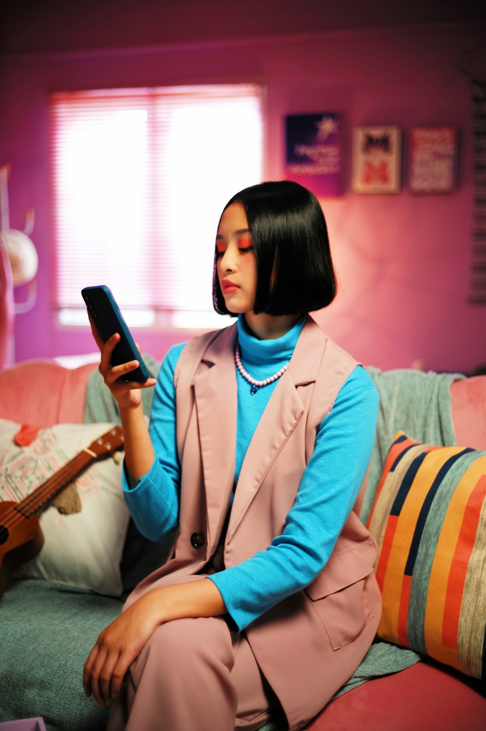 a woman sitting on a couch holding a cell phone