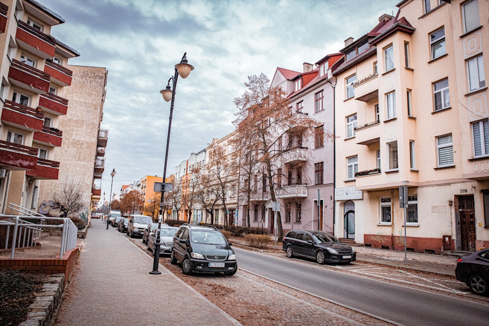 a street lined with parked cars next to tall buildings