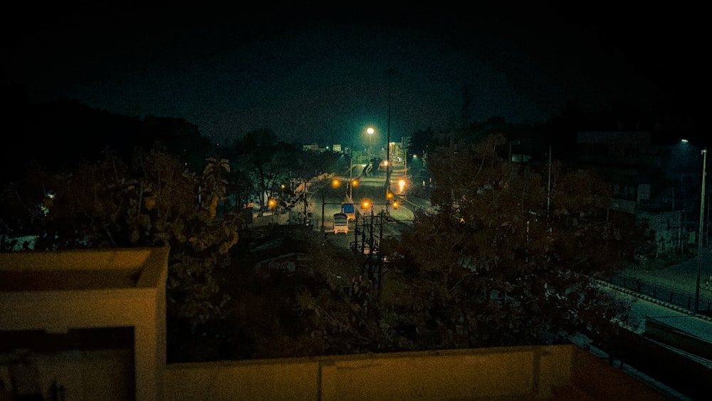 a city street at night with a train on the tracks