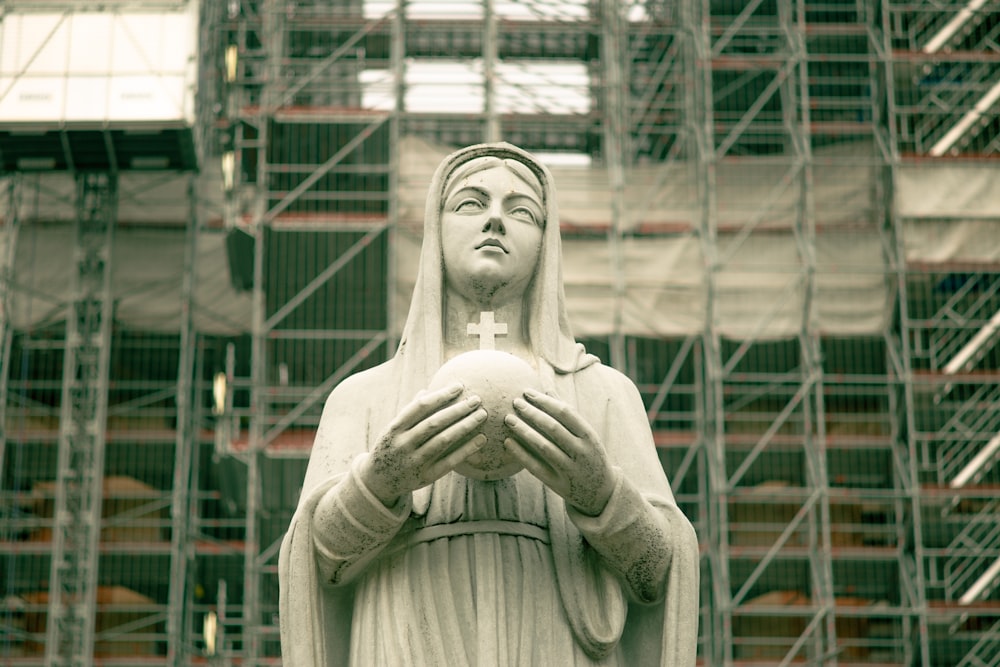 a statue of the virgin mary holding a ball