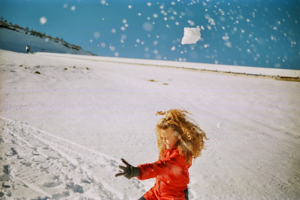 a little girl is playing in the snow