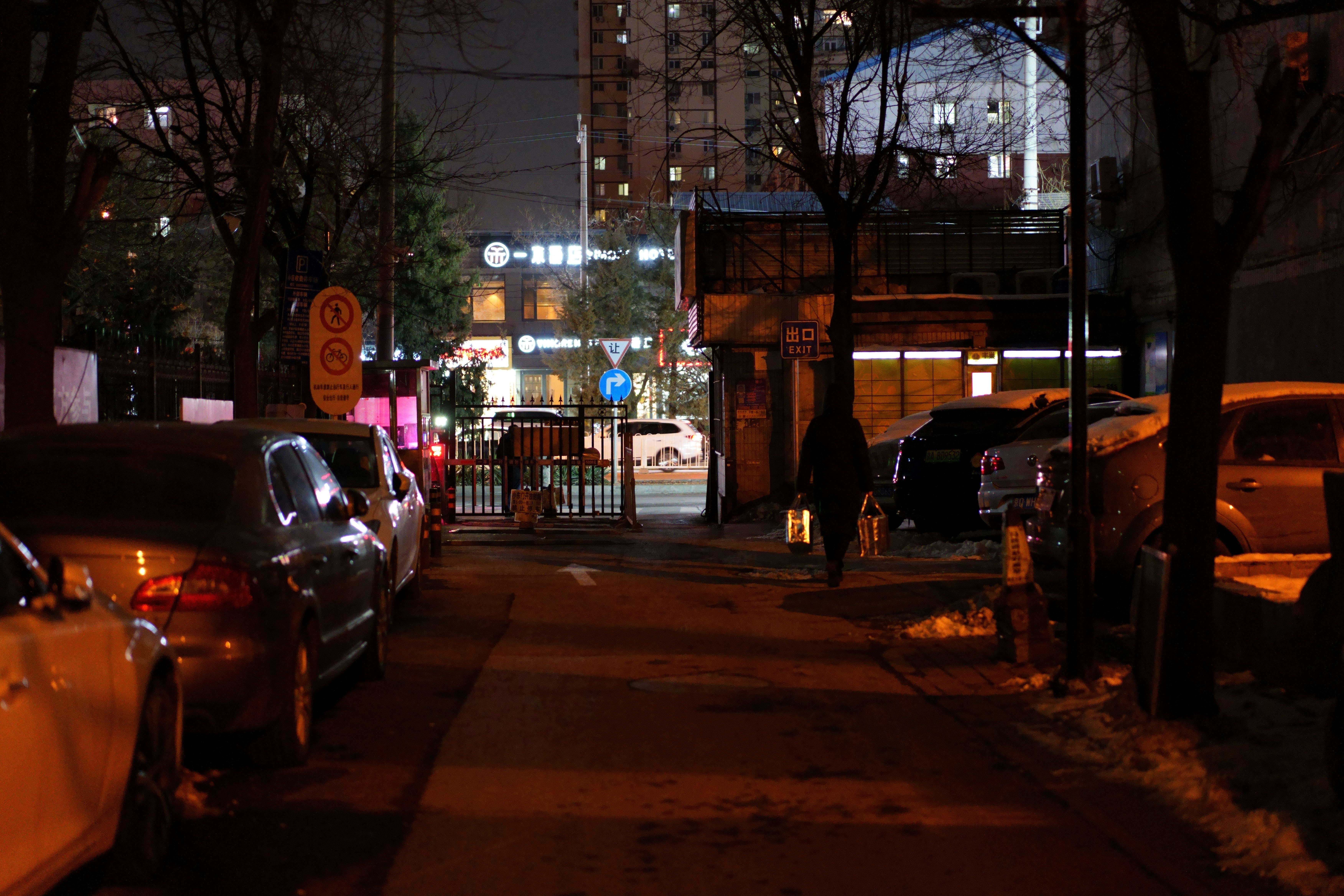 a city street at night with parked cars