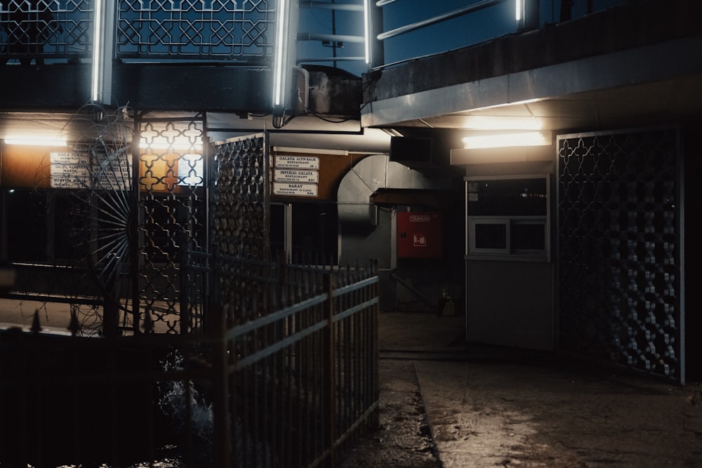 a dimly lit building with a metal fence