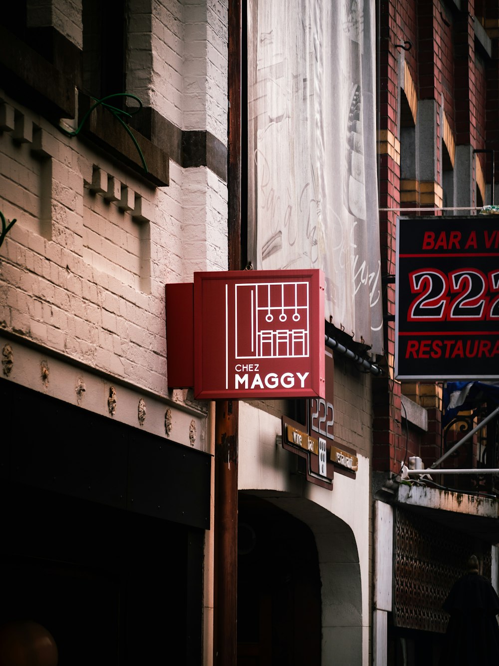 a red sign on a pole in front of a building