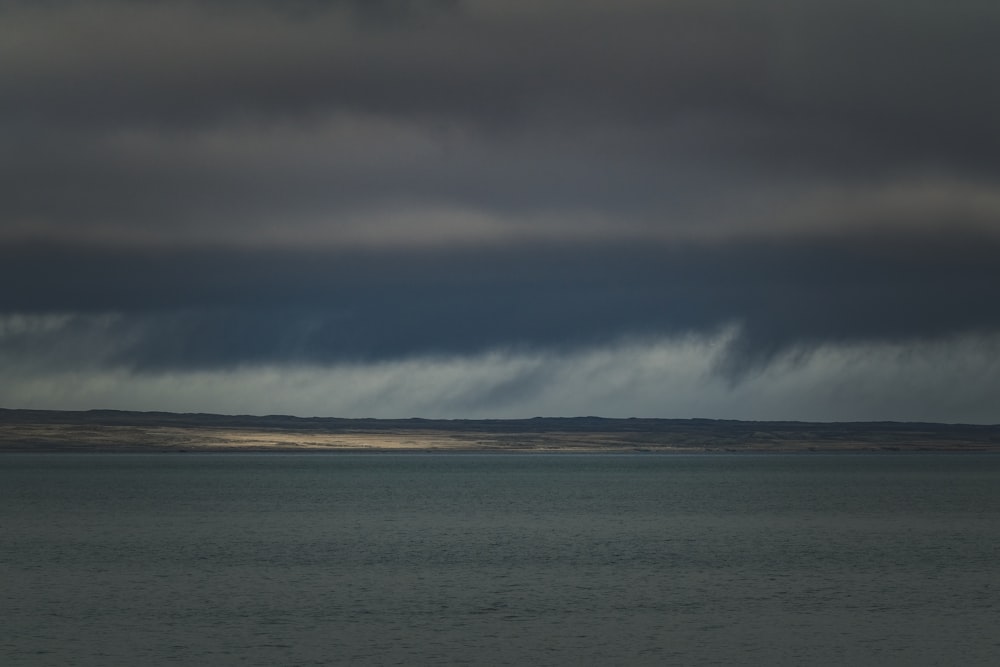 a large body of water under a cloudy sky