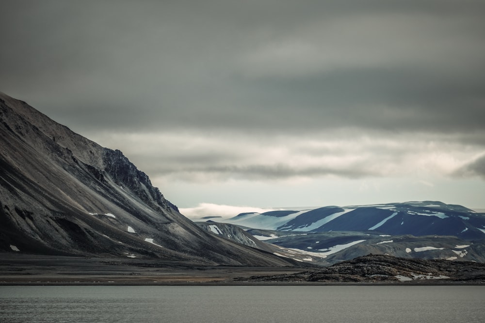 a mountain range with a body of water in the foreground