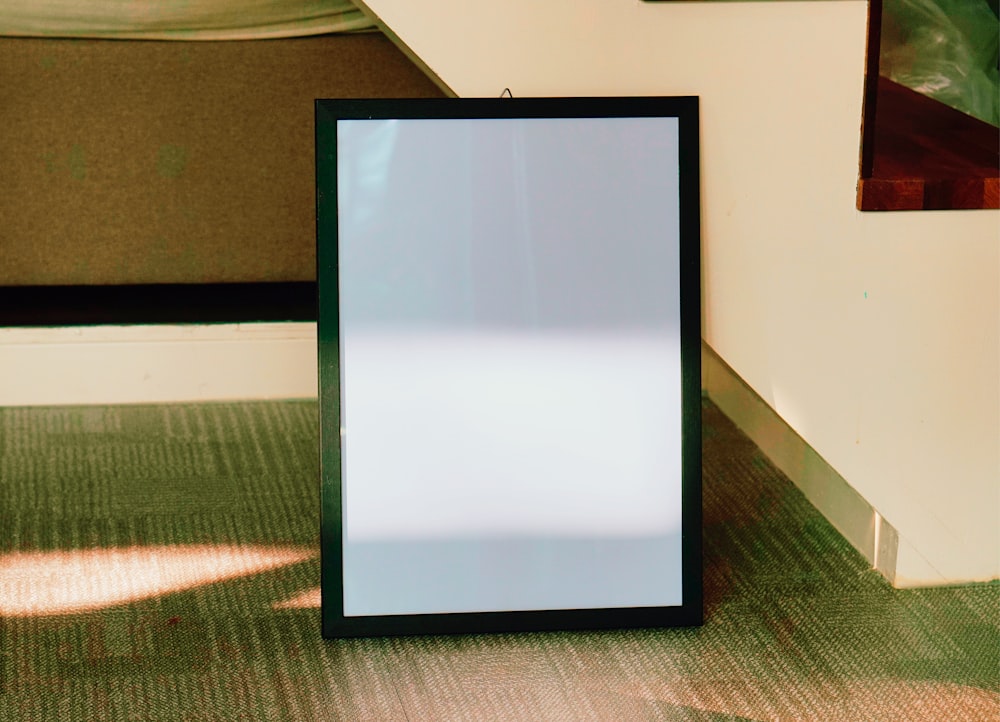 a picture frame sitting on the floor next to a wall
