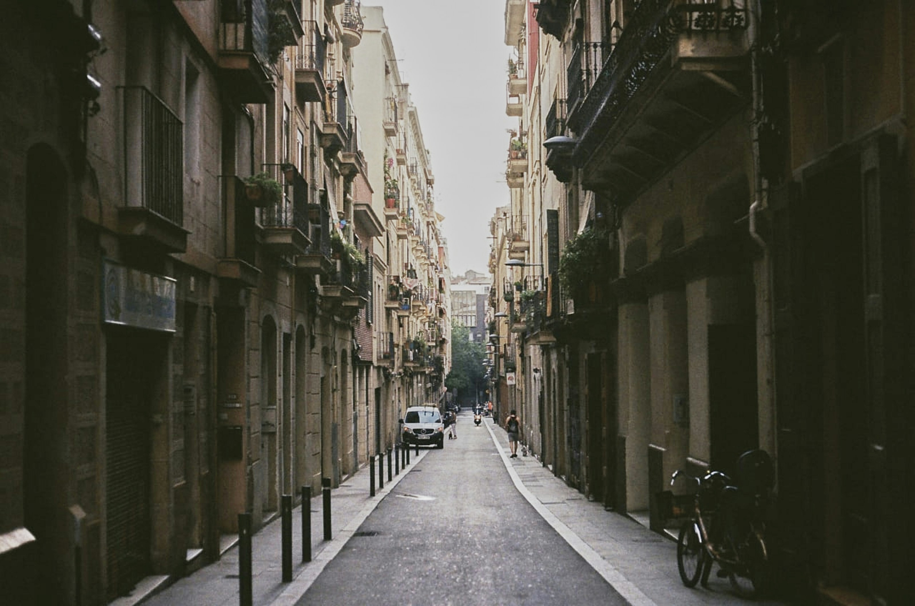 a narrow city street lined with tall buildings