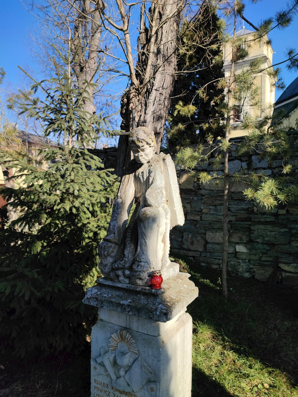 una estatua de una mujer sentada bajo un árbol