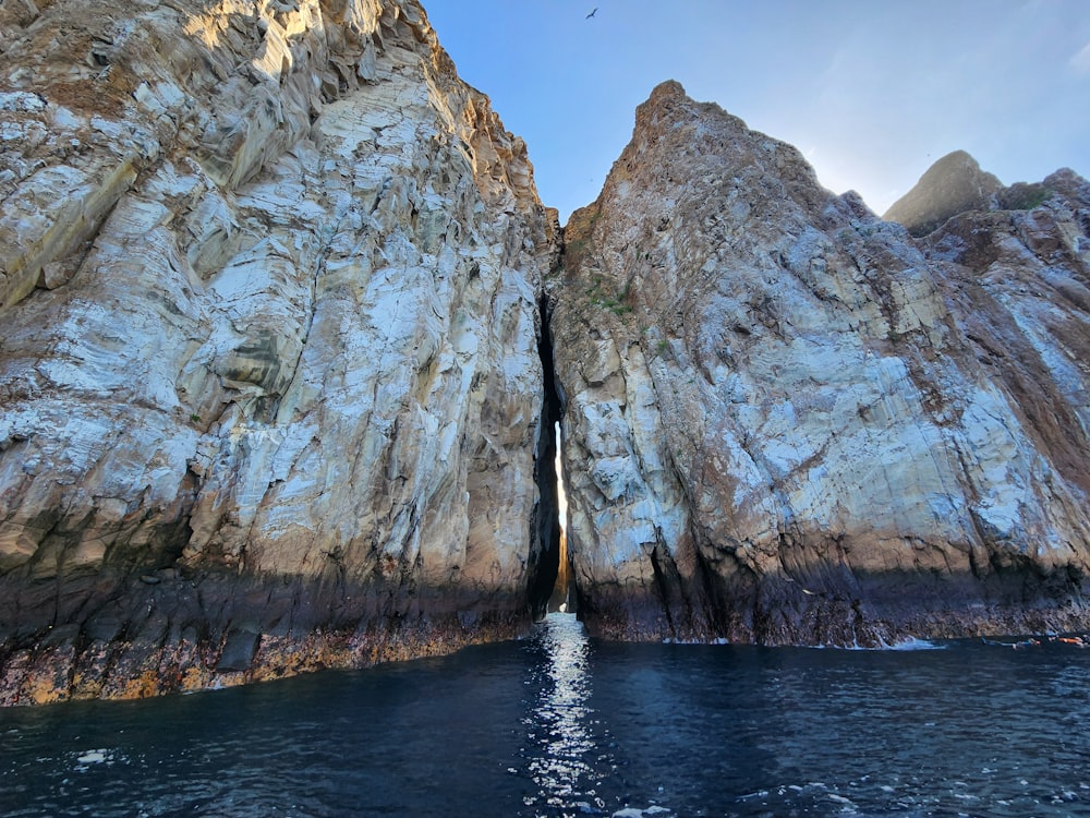 a large rock outcropping next to a body of water