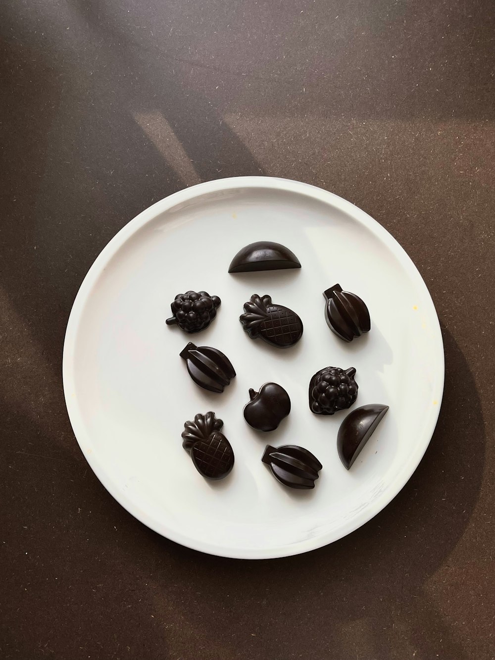 a white plate topped with chocolate pieces on top of a table