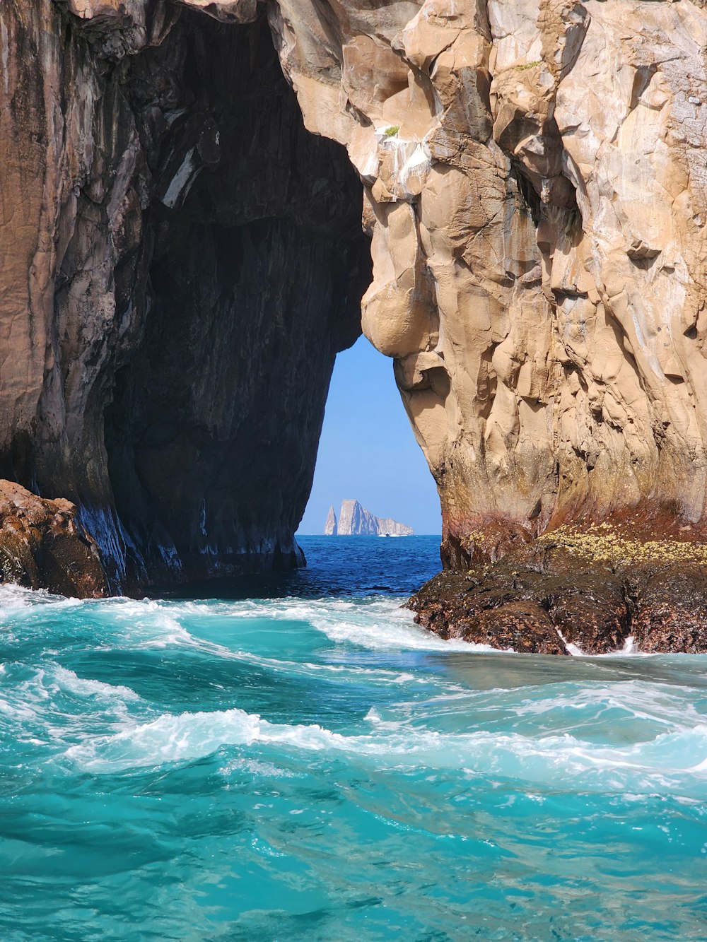 a large rock formation in the middle of a body of water