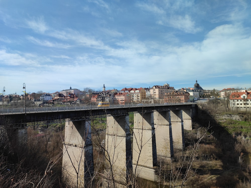 a bridge over a river with a city in the background