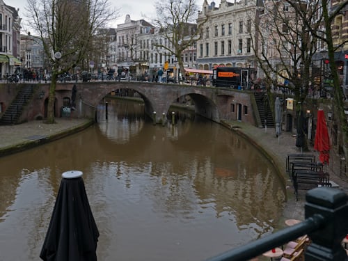 A peaceful canal in Utrecht lined with historic wharf cellars and greenery