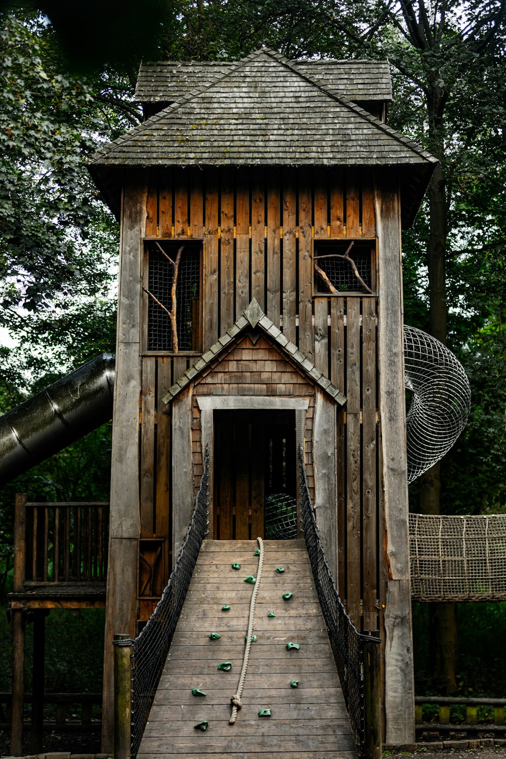 a wooden structure with a slide in the background