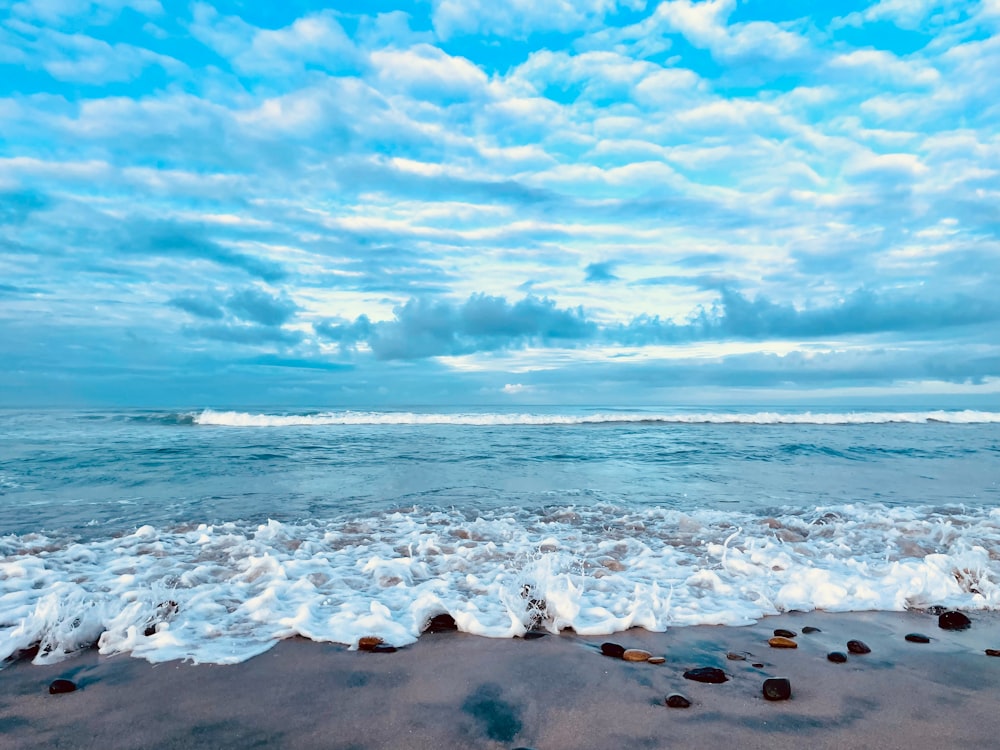 a sandy beach with waves coming in to shore