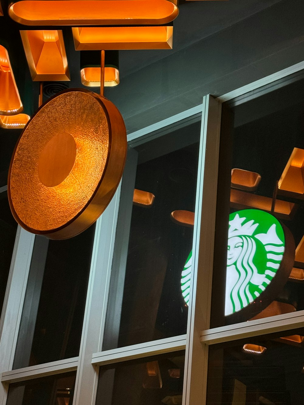a starbucks sign hanging from the side of a building