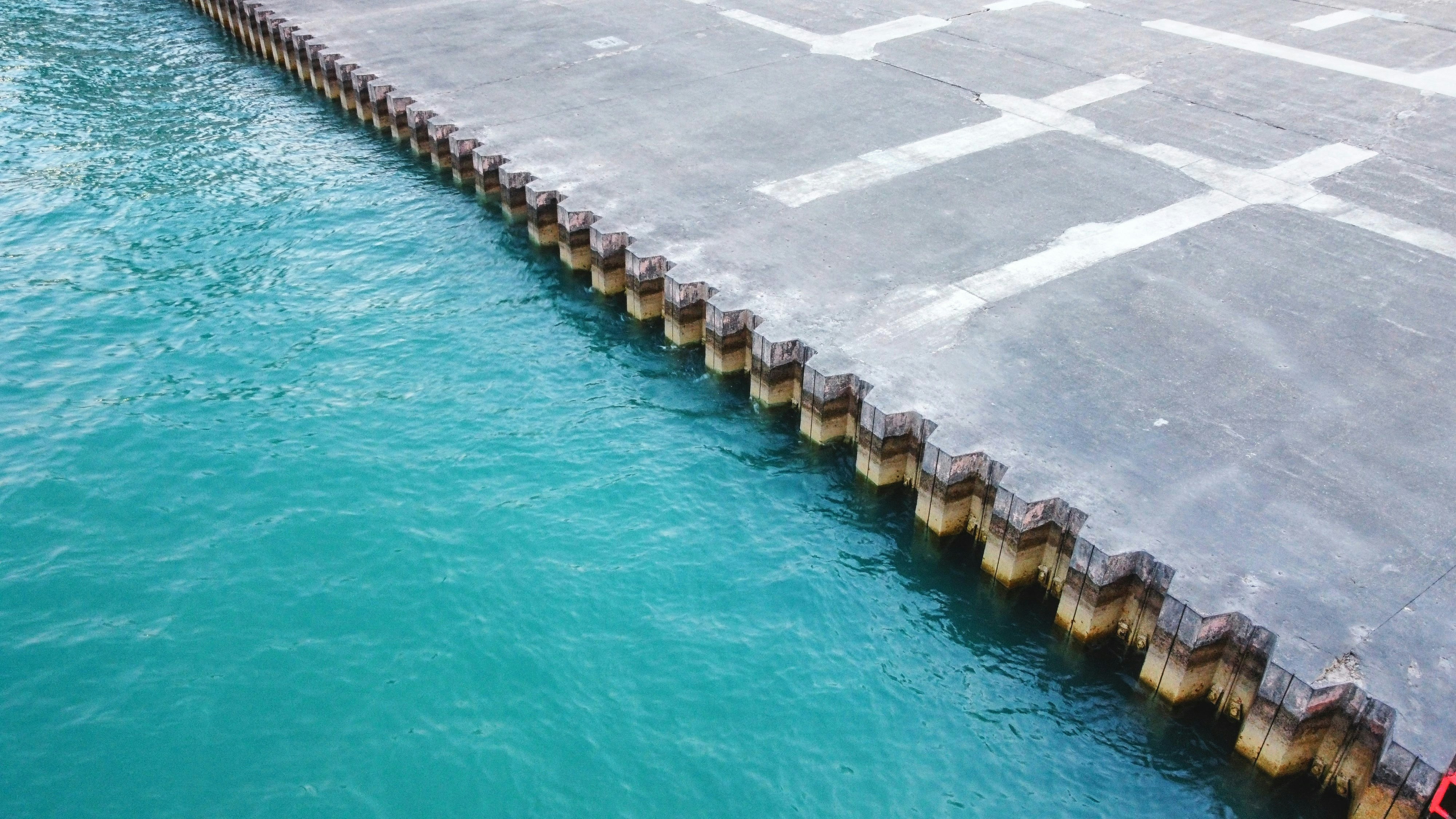 Ein Mann steht auf einem Steg neben einem Gewässer