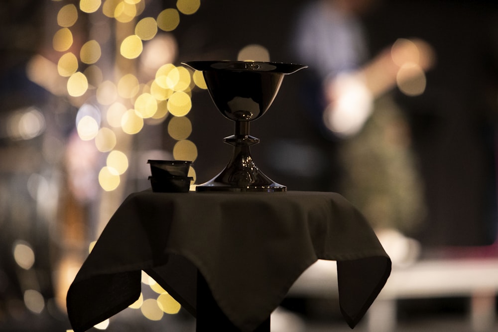 a black candle holder sitting on top of a table