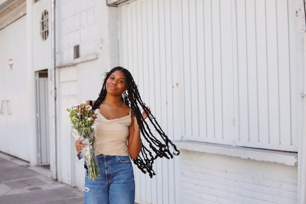 a woman holding a bouquet of flowers in her hand