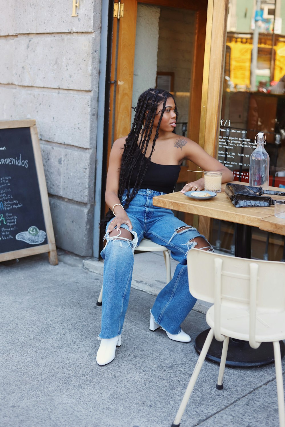 a woman sitting at a table with a cup of coffee