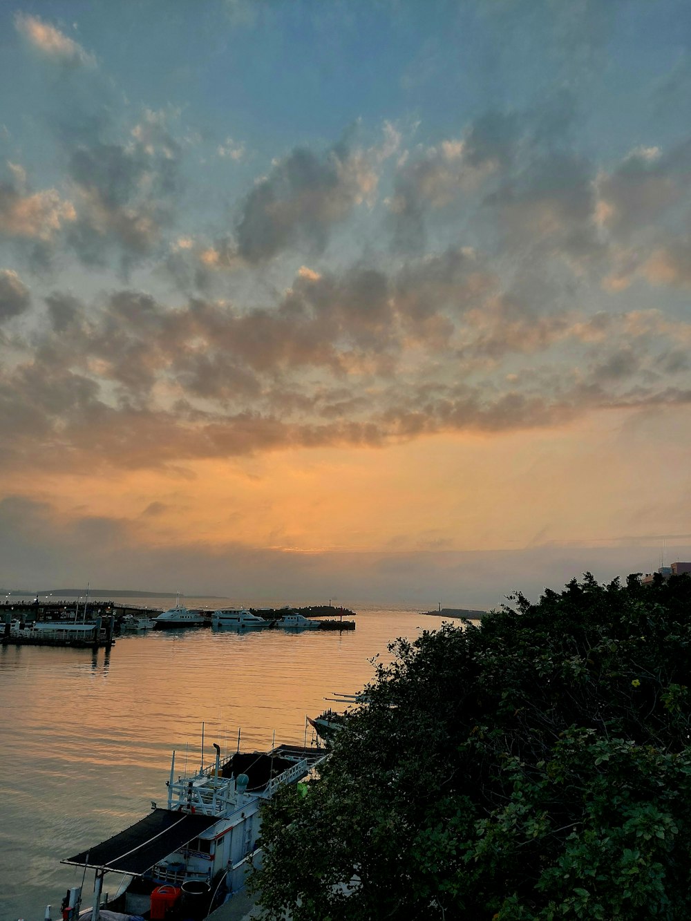 a sunset over a body of water with boats in the water