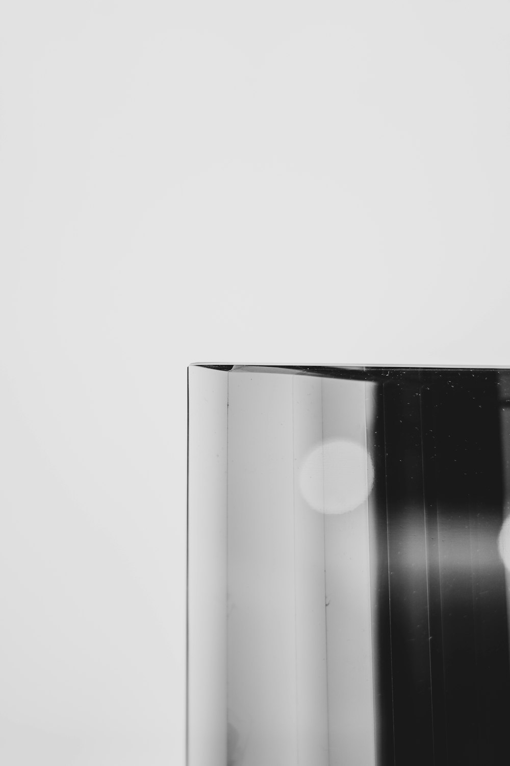 a black and white photo of a vase on a table