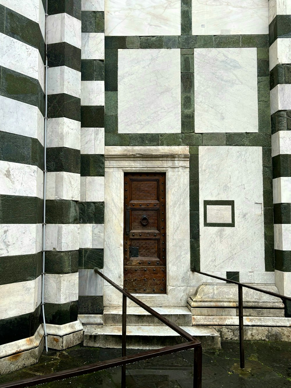 a wooden door in a white and black striped building