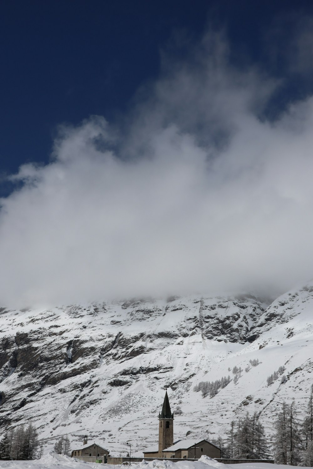 a snow covered mountain with a church in the foreground