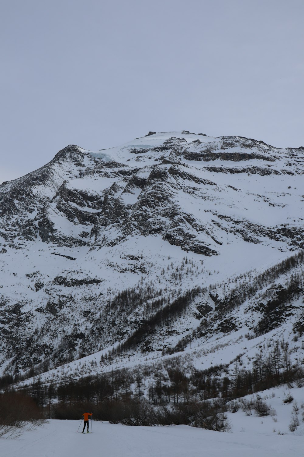 a person on skis in front of a snowy mountain