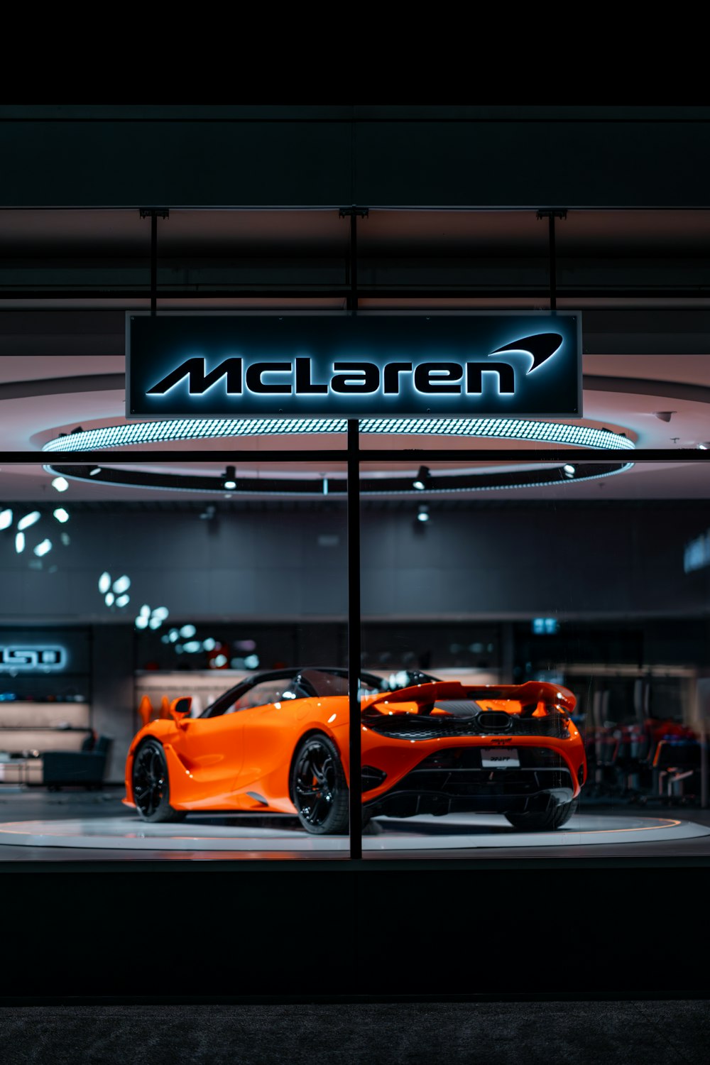 an orange sports car parked in a showroom