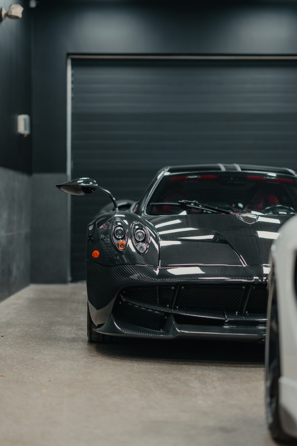 two cars parked in a garage next to each other